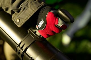 Close-up of a person's gloved hand gripping a handle of a product.
