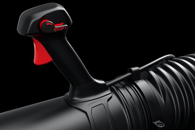 Close-up view of a black and red control handle on a cylindrical product.